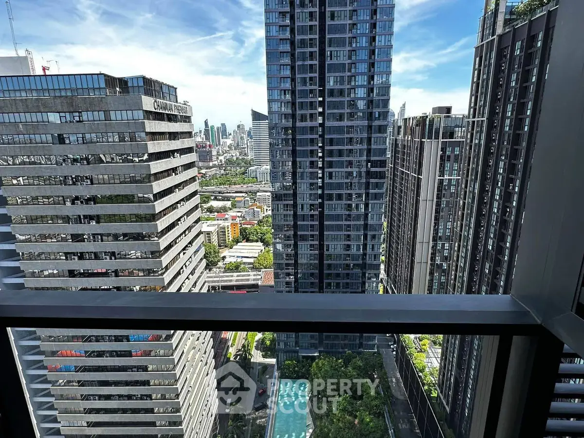 Stunning high-rise cityscape view from a modern balcony overlooking urban skyline and pool.