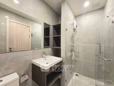 Modern bathroom with sleek design, glass shower, and elegant fixtures in a contemporary apartment.