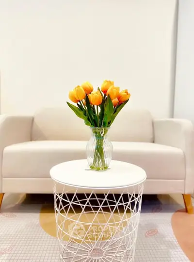 Stylish living room with modern white sofa and elegant floral centerpiece on designer table.