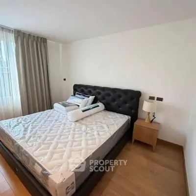Modern bedroom with stylish bed and natural light, perfect for relaxation.