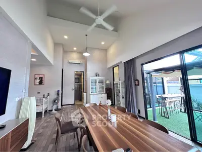 Spacious modern living room with high ceiling and elegant dining area