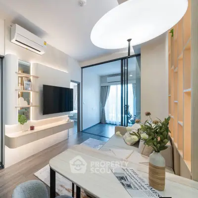 Modern living room with stylish decor and open layout, featuring a wall-mounted TV and elegant lighting.