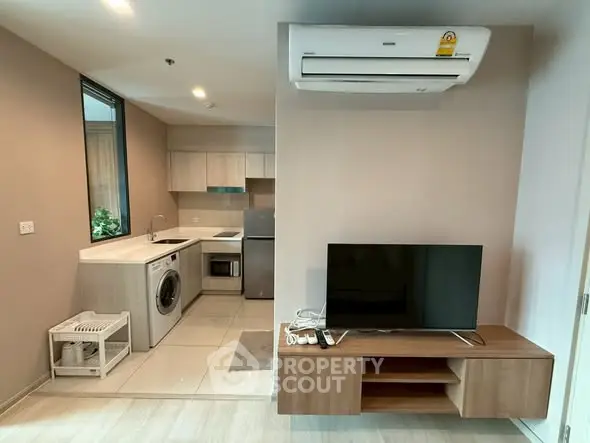Modern apartment interior with kitchen and living area featuring sleek appliances and stylish decor.