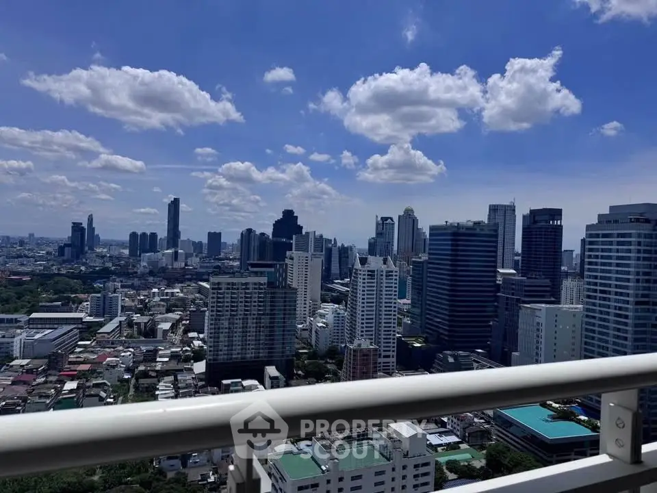 Stunning cityscape view from high-rise balcony with clear blue sky.