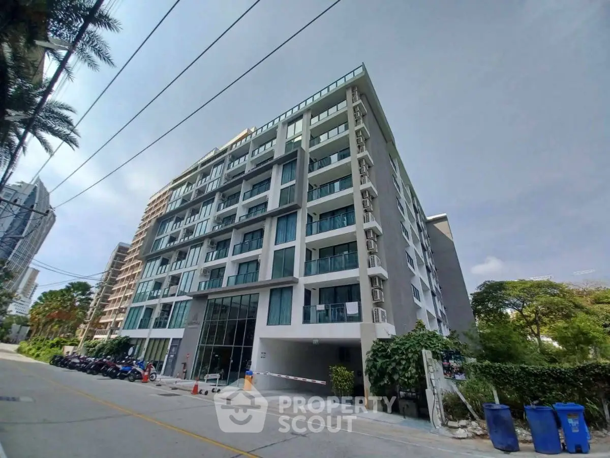Modern multi-story residential building with balconies and street view