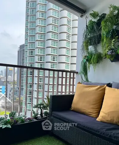 Charming balcony with cozy seating and lush greenery overlooking cityscape.