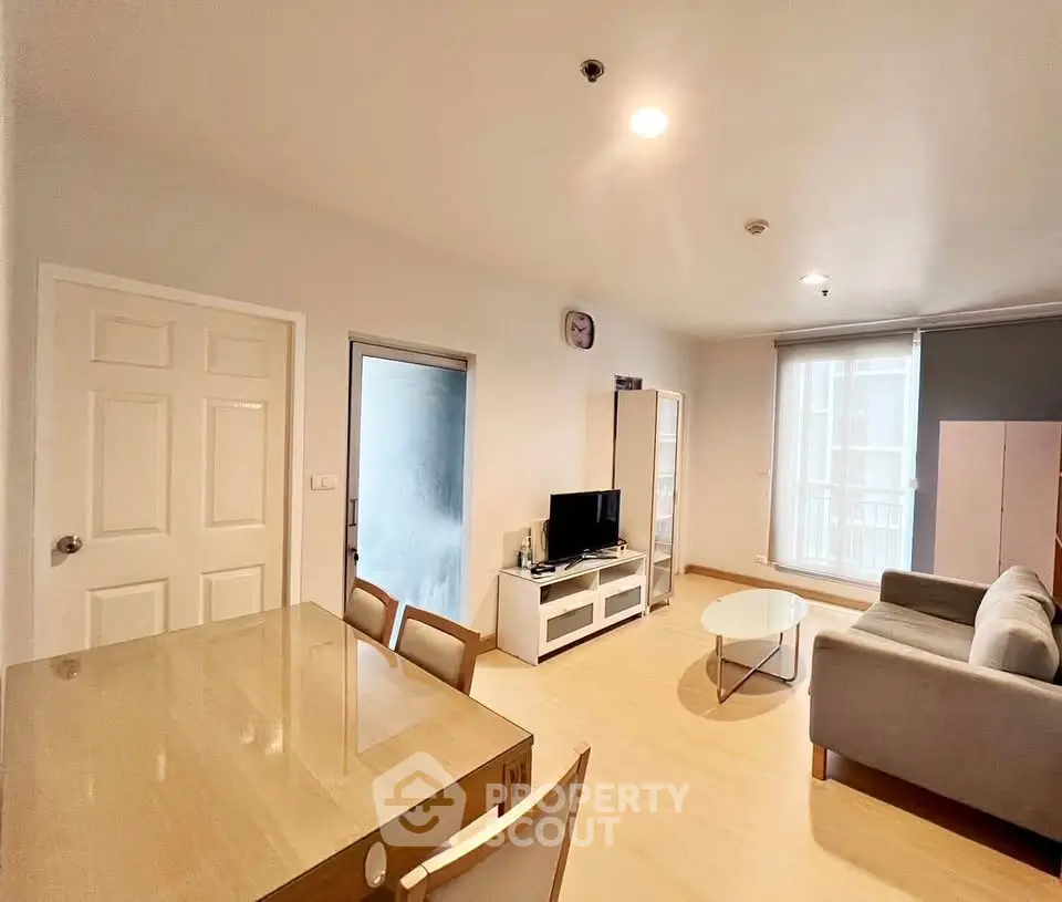 Spacious living room with modern furniture and natural light, perfect for relaxation and entertainment.
