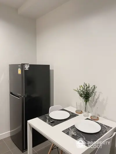 Modern kitchen with sleek black fridge and stylish dining setup