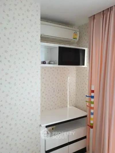 Charming bedroom corner with air conditioning and floral wallpaper, perfect for cozy living.