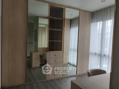 Spacious modern bedroom with built-in wooden wardrobe and large windows