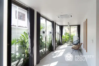 Bright sunroom with large windows and modern decor, perfect for relaxation and natural light.