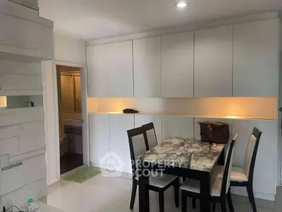 Modern dining area with marble table and sleek cabinetry in a stylish apartment.