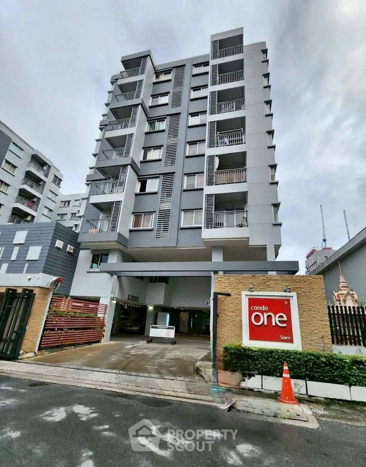 Modern condominium building with sleek design and spacious balconies in urban setting.