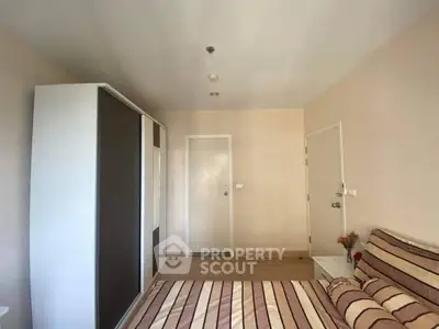 Cozy bedroom with modern wardrobe and striped bedding