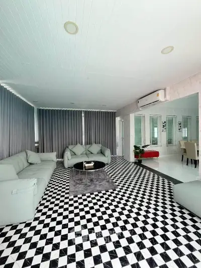 Spacious modern living room with stylish checkered flooring and elegant furniture.