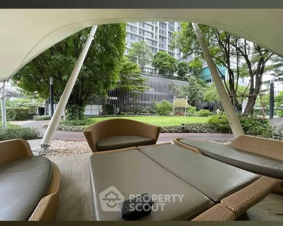 Luxurious garden view from modern outdoor seating area in upscale residential complex.