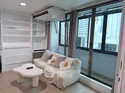 Chic living room with cozy sofa and large windows offering city views, perfect for urban living.