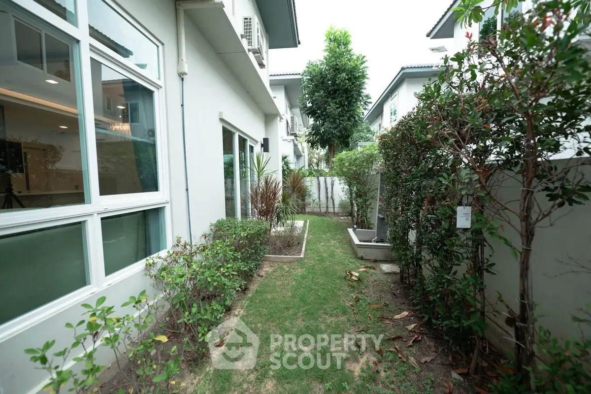 Charming garden view of modern home with lush greenery and large windows