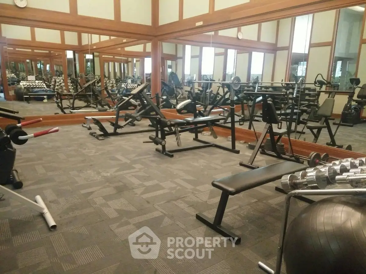 Spacious gym with modern equipment and mirrored walls for fitness enthusiasts.