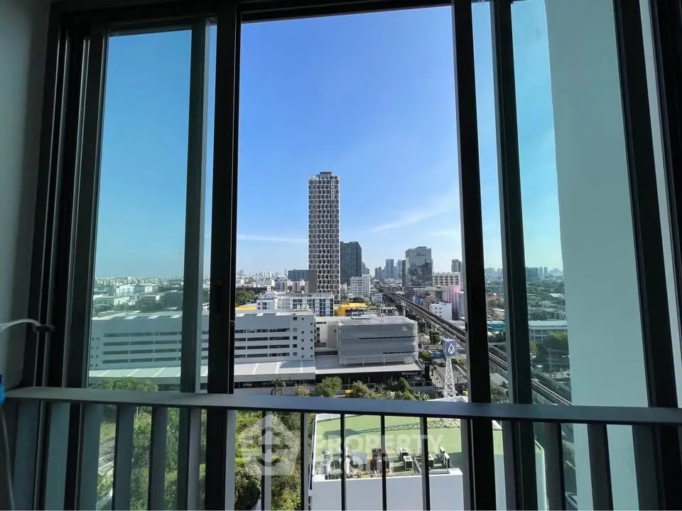 Stunning cityscape view from high-rise balcony with clear blue sky.