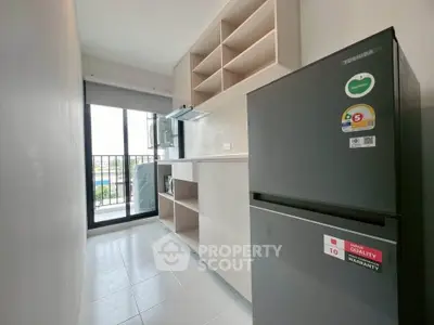 Modern kitchen with sleek appliances and open shelving, featuring a large window for natural light.