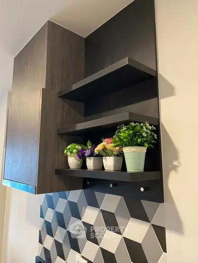 Modern kitchen with geometric backsplash and stylish shelving with potted plants.