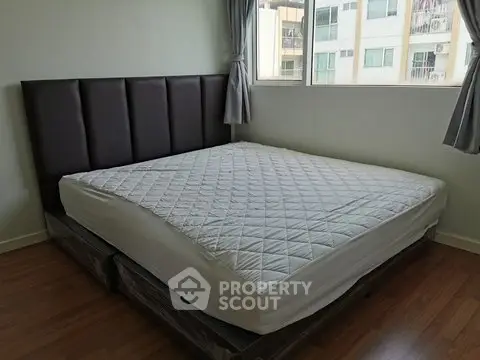 Spacious bedroom with large bed and window view in modern apartment
