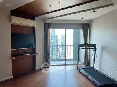 Modern living room with treadmill and balcony view in high-rise apartment.