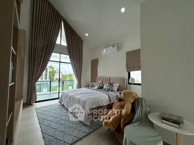 Luxurious bedroom with high ceilings and large windows offering natural light and scenic views.