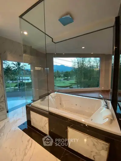 Luxurious bathroom with jacuzzi and stunning mountain view, perfect for relaxation.