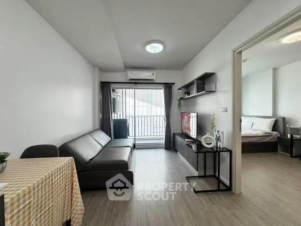 Modern living room with sleek furniture and open view to bedroom, ideal for urban living.