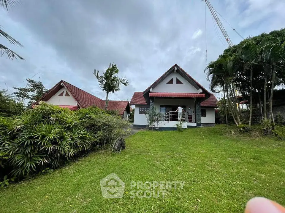 Charming countryside house with red roof and lush green garden