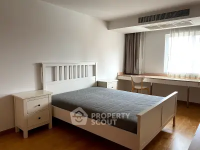Spacious bedroom with modern furniture and natural light
