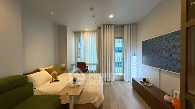 Modern bedroom with stylish decor and natural light, featuring a cozy bed and elegant furnishings.