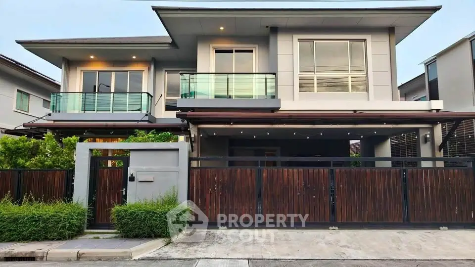 Modern two-story house with sleek design and spacious balcony in a suburban neighborhood.