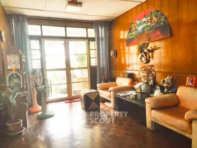 Charming vintage living room with wooden paneling and cozy seating area, perfect for relaxation.