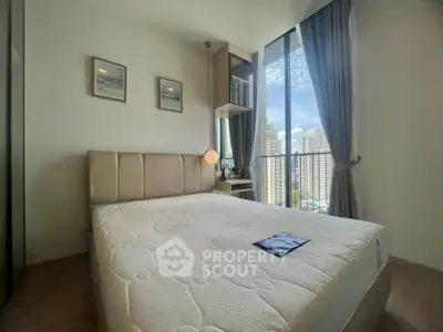 Modern bedroom with large windows offering stunning city views and elegant decor.