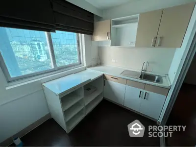 Compact kitchen with city view, featuring modern cabinetry and sleek countertops.