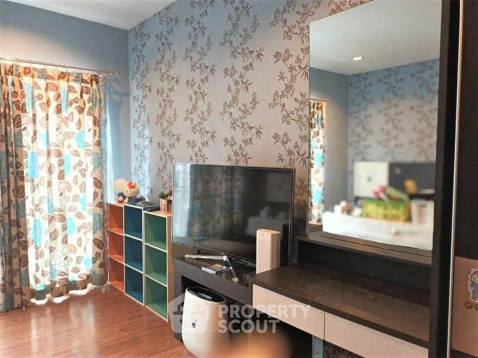 Charming living room with floral wallpaper and modern TV setup