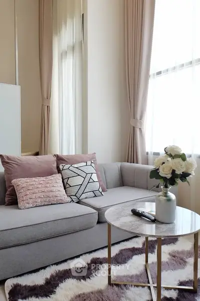 Chic living room with plush sofa, stylish cushions, and elegant curtains, perfect for modern comfort.