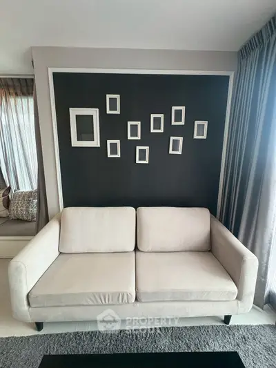 Modern living room with stylish sofa and decorative wall frames, perfect for contemporary urban living.