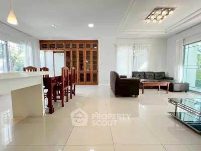 Spacious modern living room with elegant dining area and large windows for natural light.