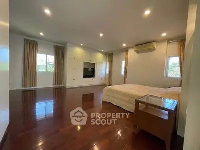 Spacious bedroom with wooden floors and built-in storage, perfect for modern living.