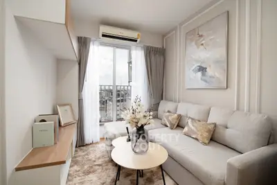 Modern living room with elegant decor and natural light, featuring a cozy sofa and stylish artwork.