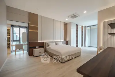 Luxurious modern bedroom with spacious layout and elegant design, featuring large windows and stylish furnishings.