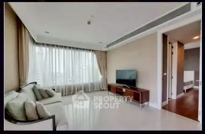Spacious modern living room with large windows and elegant decor in a luxury apartment.