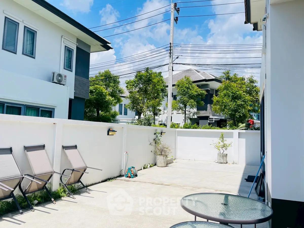 Spacious outdoor patio with modern seating in a sunny residential area