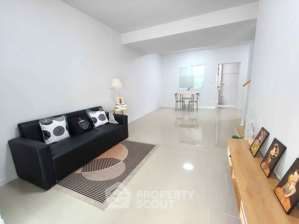 Spacious modern living room with sleek black sofa and stylish decor