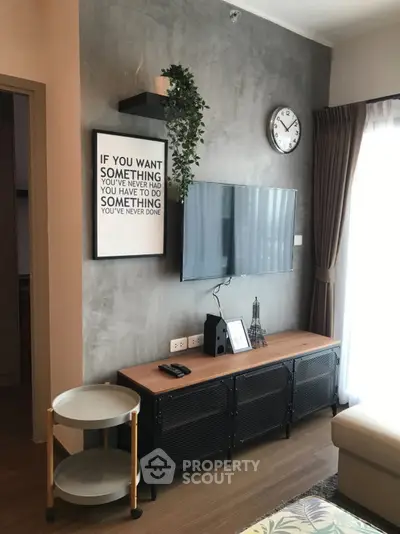 Modern living room with stylish decor and wall-mounted TV in a cozy apartment setting.