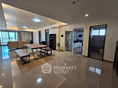 Spacious open-plan living and dining area with modern kitchen and city view.